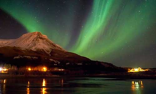 Norrsken som sveper förbi vacker berg på Island