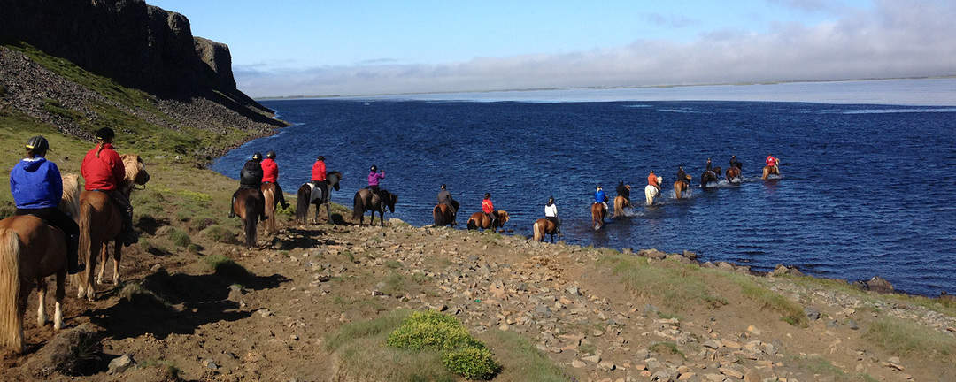 Ridsällskapet är på väg ut i den grunda sjön Hóp på Island