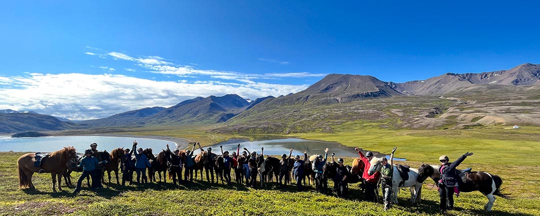 Nöjda och glada ryttare vinkar efter ridresa i Flateyjardalur på Island
